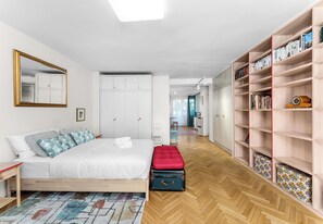A bedroom with a bed, a wardrobe, a bookshelf, and a mirror. - Retoryka Old Town Colorful Studio (Kraków)