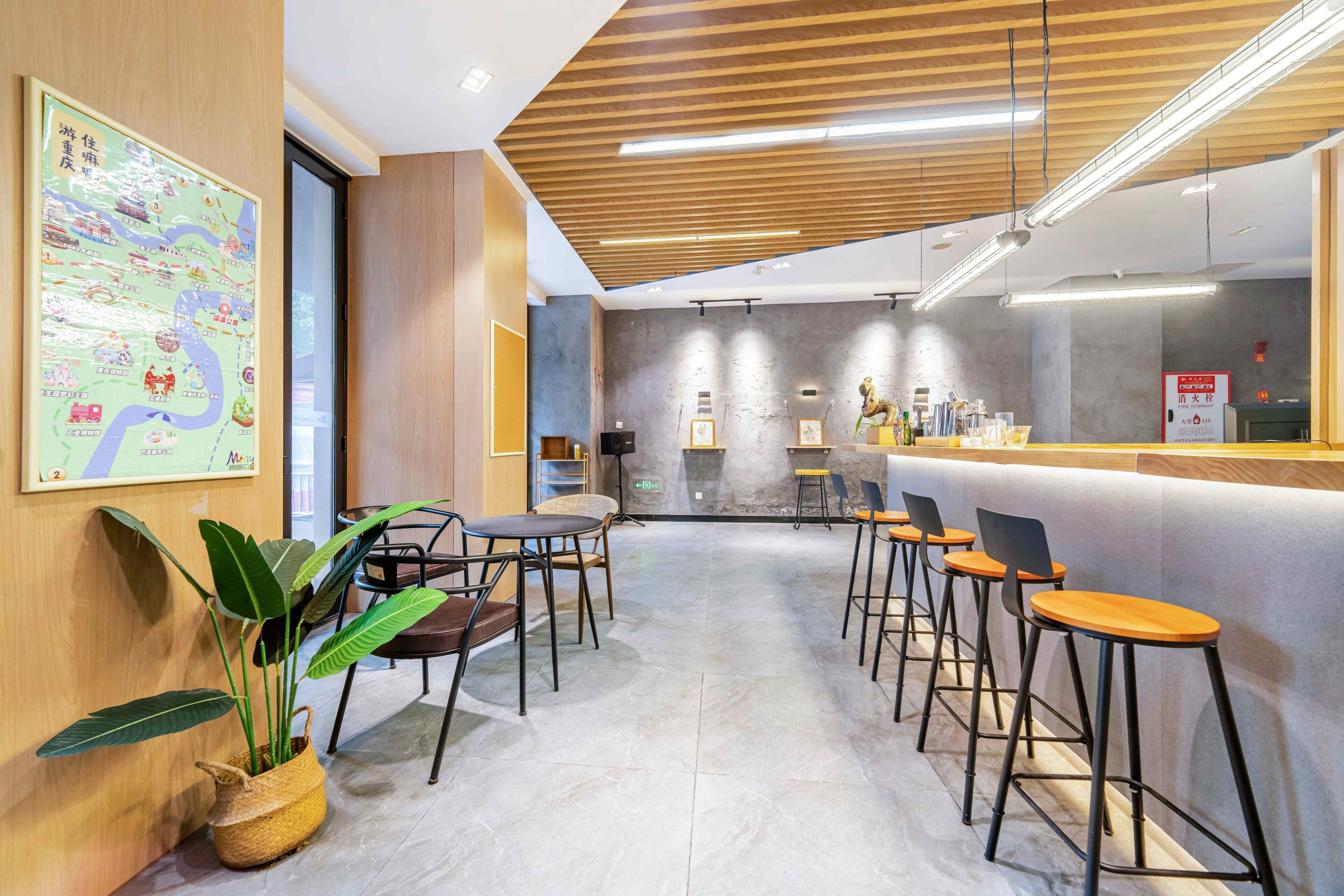 A modern interior with a bar area, seating, and a map on the wall.