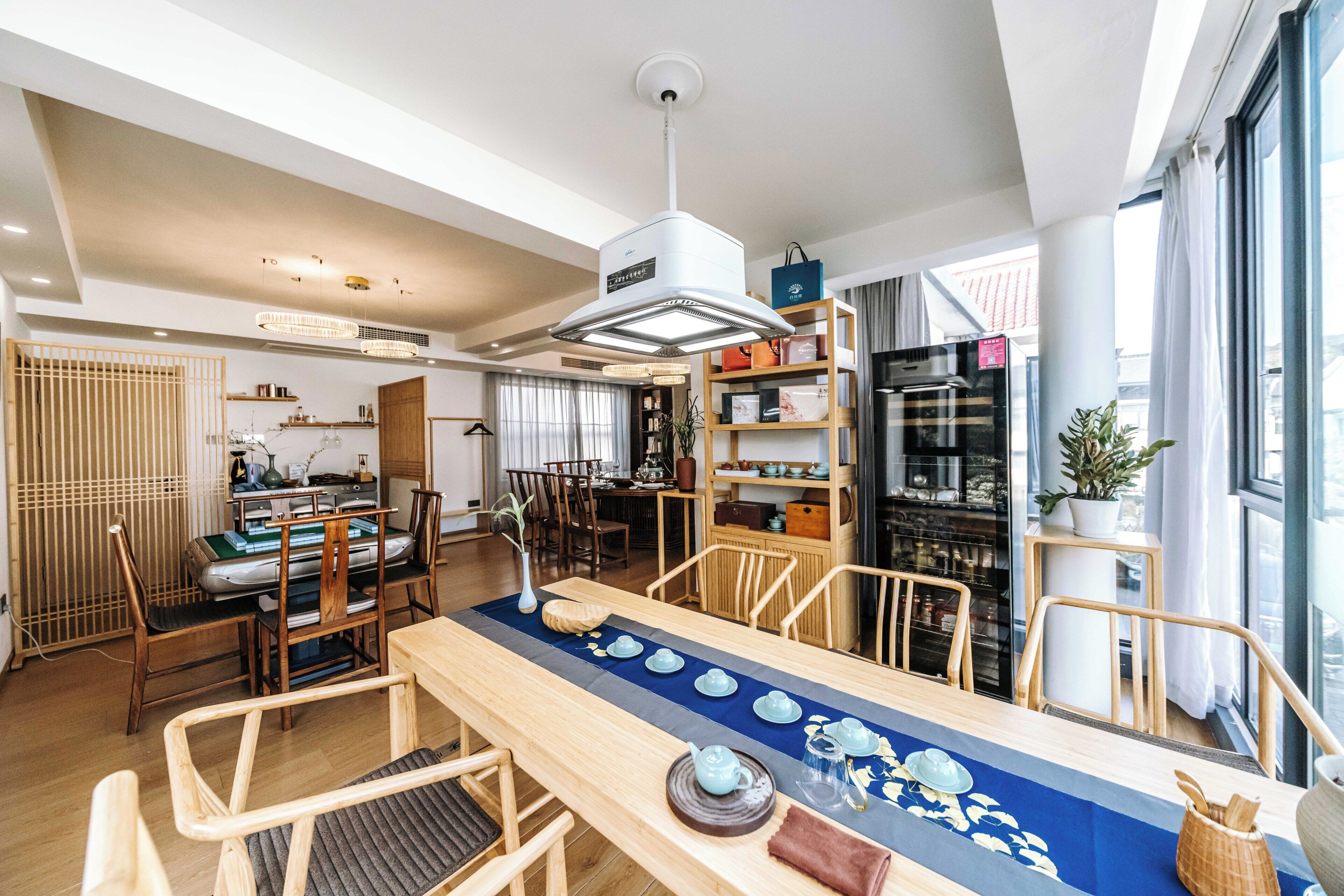 A modern kitchen with a dining area, wooden furniture, and a view of the city.