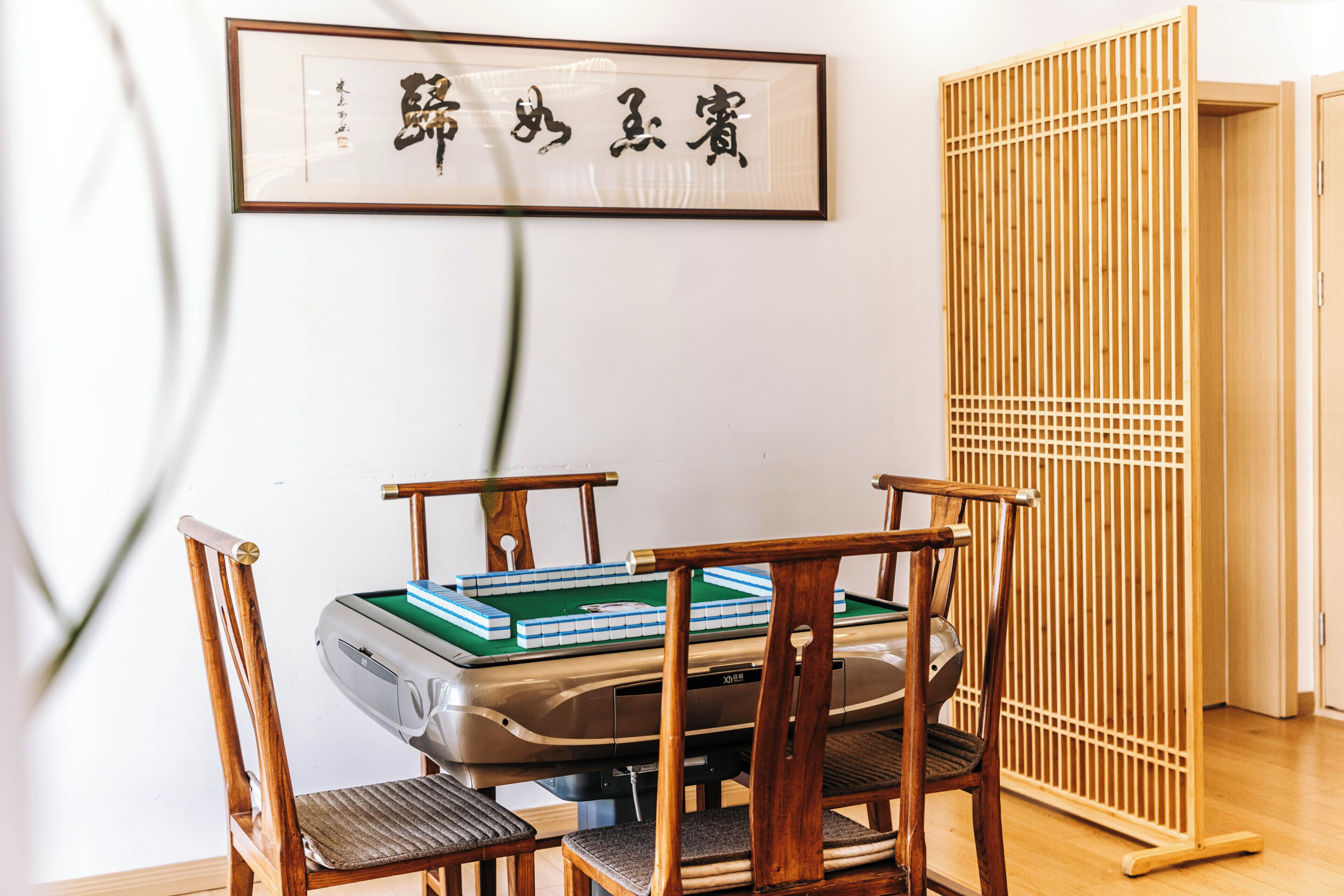 A room with a tatami mat table, wooden chairs, a snooker table, and a shoji screen.