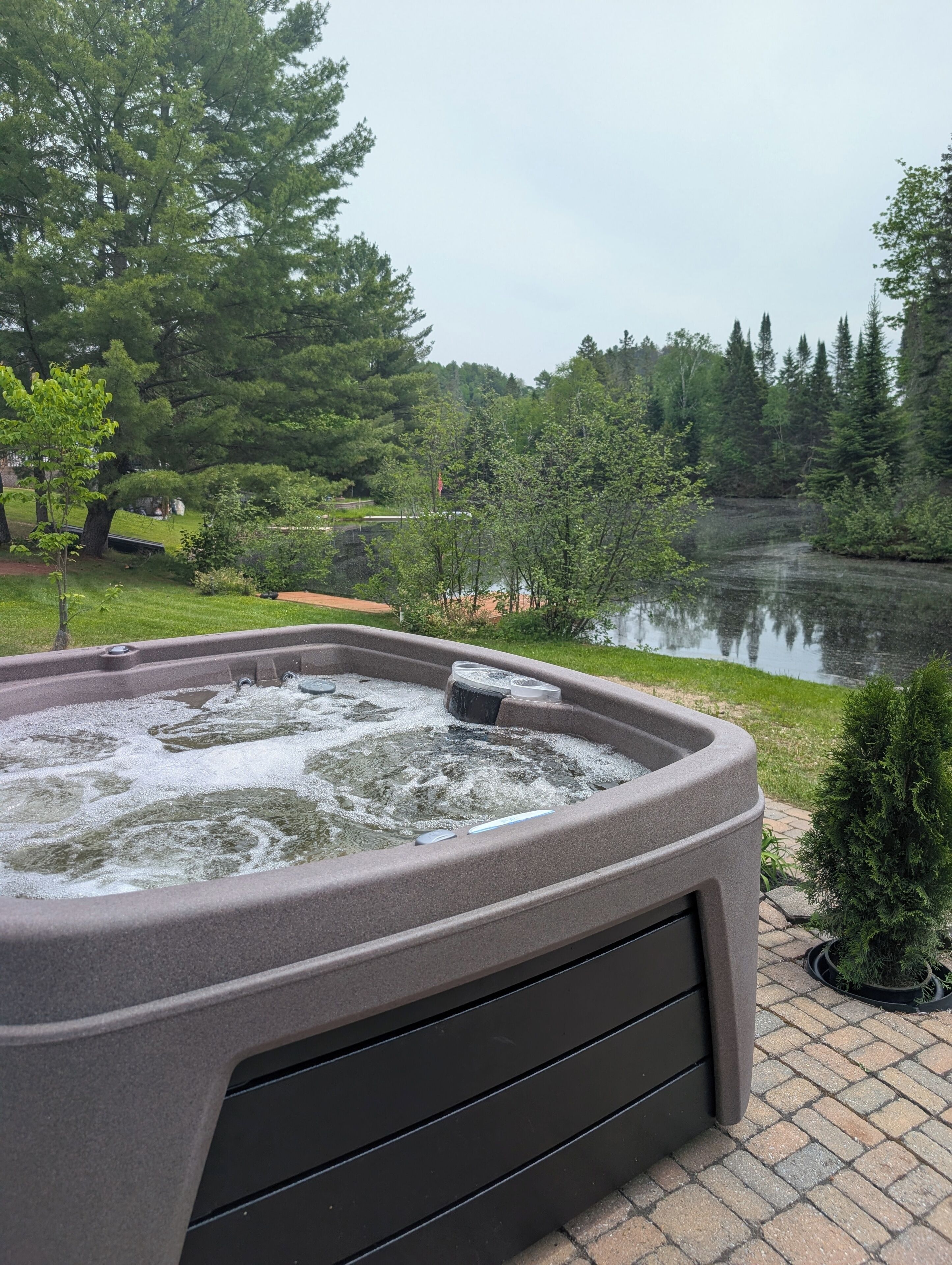 Un jacuzzi con vista a un lago y árboles.