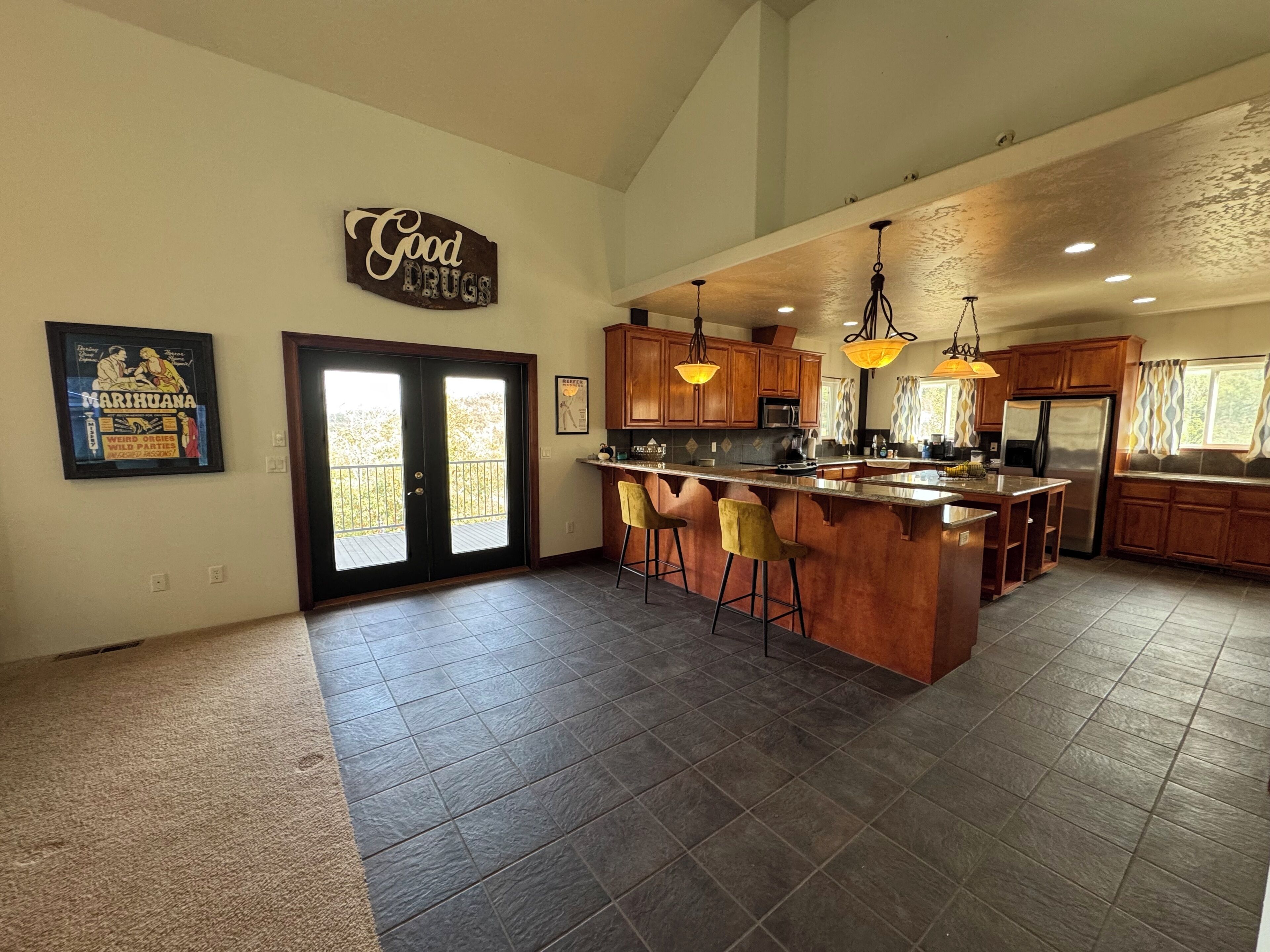 A spacious kitchen with a large island, wooden cabinets, and pendant lighting.