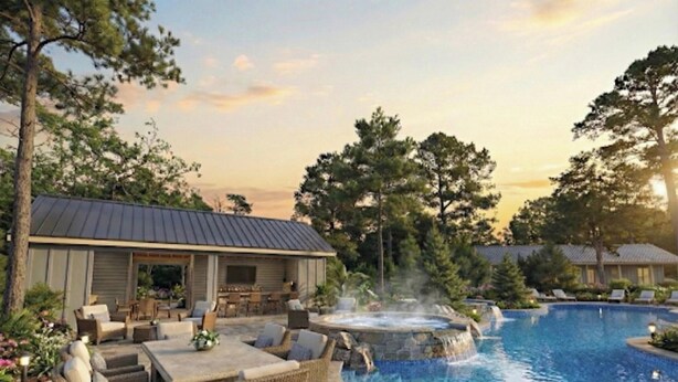 Una piscina con hidromasaje, mobiliario exterior y una zona cubierta con techo metálico.