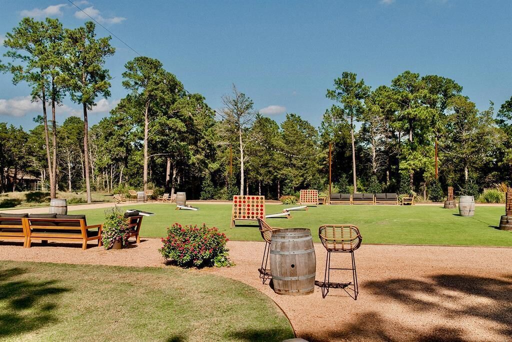A well-maintained outdoor area with a wooden bench, a barrel chair, and a small garden.