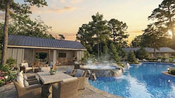 En swimmingpool med jacuzzi og udendørs siddeområde.