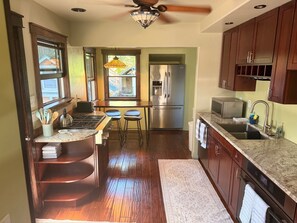 A kitchen with a central island, a refrigerator, a microwave, and wooden cabinets.
