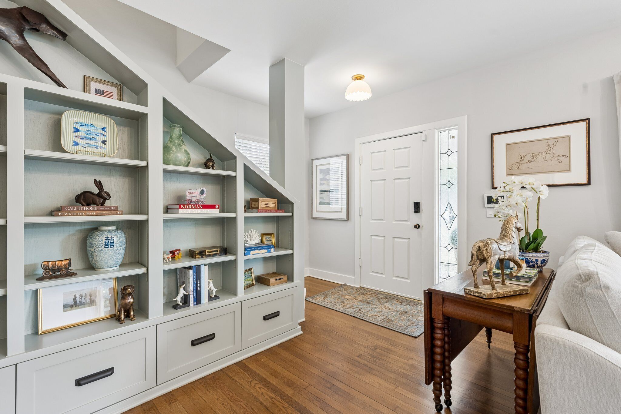 A living room with a built-in bookshelf, a wooden coffee table, and a white door.
