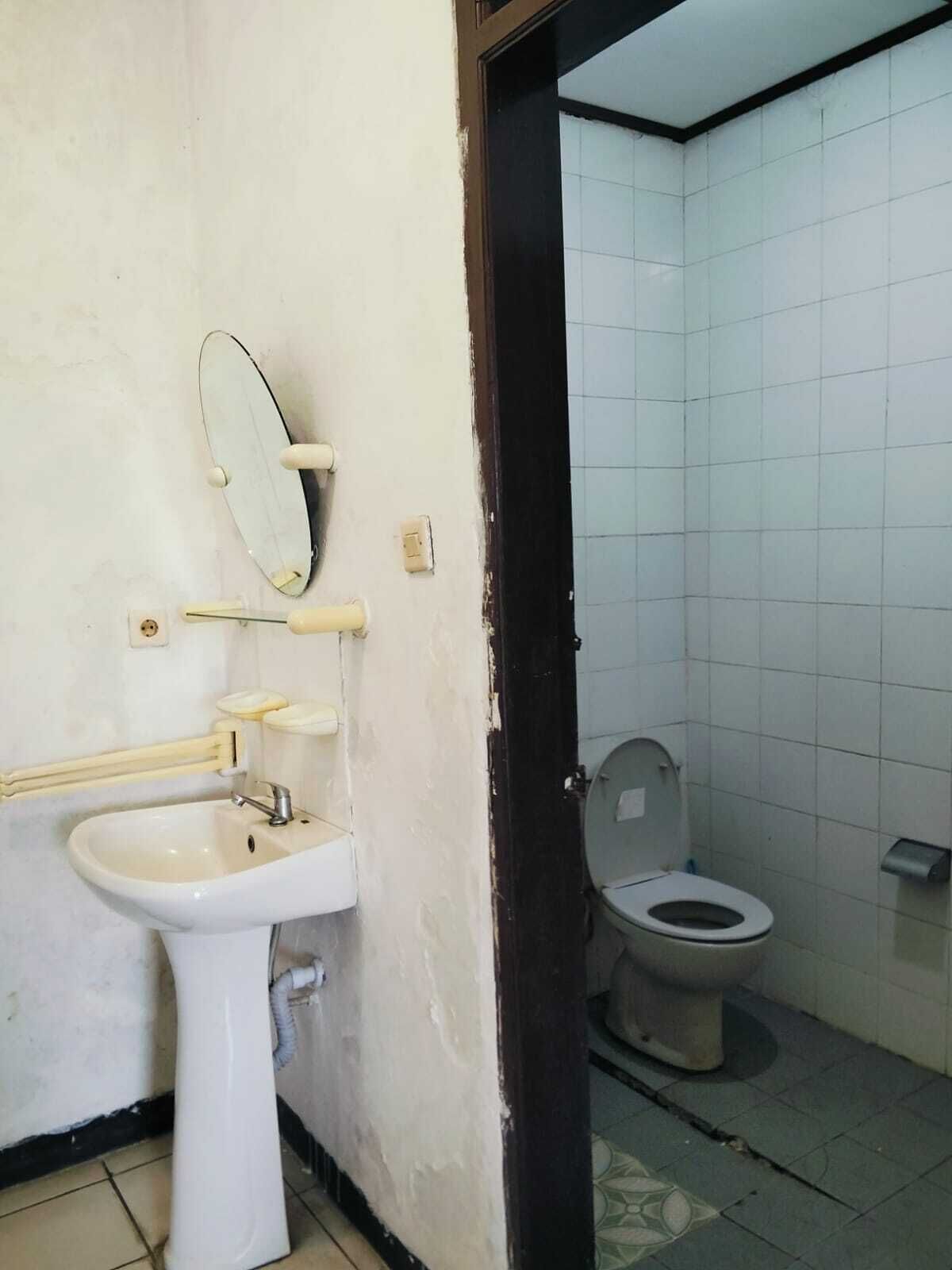 Un baño con lavamanos, espejo e inodoro.