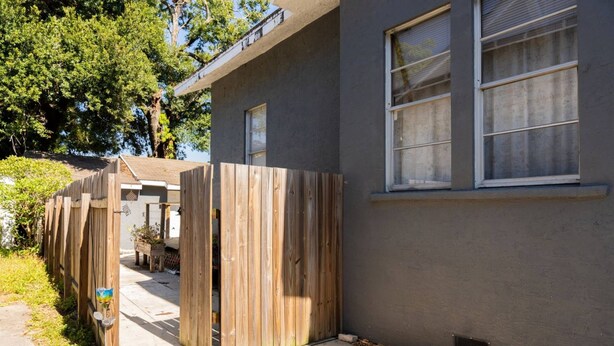 A residential building with a wooden fence, a window, and a door. - El Apartemento | Cozy 1BR Cottage with Private Deck Near Ybor City, Armature Works & Downtown Tampa (Tampa)