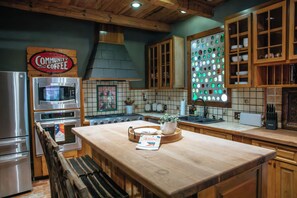 Una cocina con armarios de madera, un refrigerador de acero inoxidable, un microondas y una estufa.