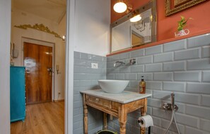 Une salle de bain avec un meuble-lavabo en bois, un lavabo blanc et un miroir au-dessus.