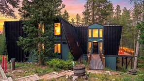 A modern cabin with a sloped roof, large windows, and a wooden deck. - Pitch & Pine by Avantstay Hot Tub + Ping Pong + Arcade + Loft Lounge Ski, Hike + Main Street (Breckenridge)