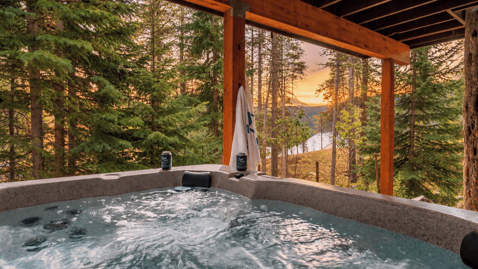 A hot tub with a view of a forest and mountains.