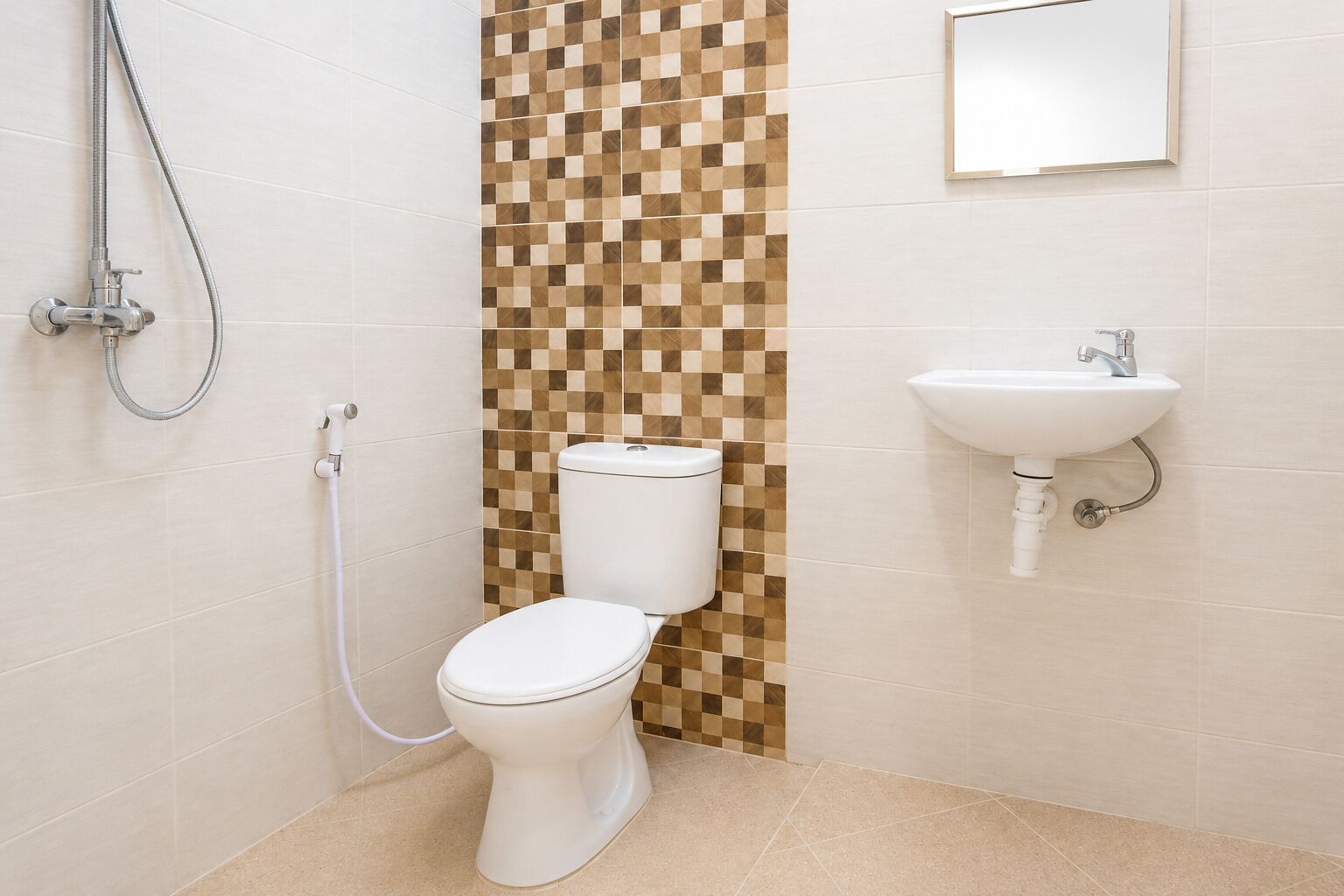 A bathroom with a toilet, a shower, and a sink.