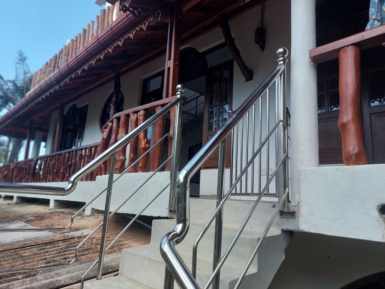 Una scala con ringhiere in metallo che conduce a un edificio con un balcone in legno.