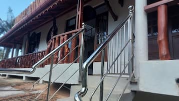 Una escalera con barandillas de metal que conduce a un edificio con balcón de madera.