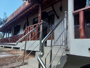 Una escalera con barandillas de metal que conduce a un edificio con balcón de madera.