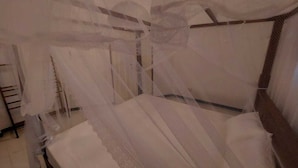 Un lit à baldaquin avec une tête de lit en bois.