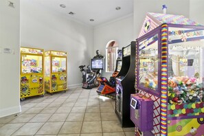 Eine Reihe von Spielautomaten in einem Raum mit Fliesenboden und weißen Wänden.