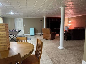 A living room with a foosball table, a sofa, and a TV. - Spacious 4-bedroom house at peaceful Lake McConaughy. (Brule)