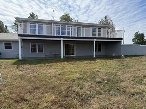A two-story building with a balcony, large windows, and a flat roof. - Spacious 4-bedroom house at peaceful Lake McConaughy. (Brule)
