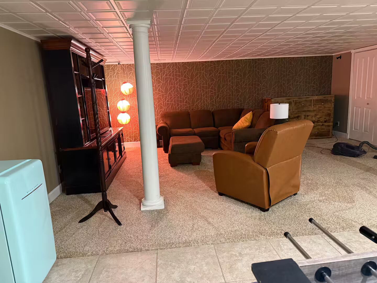 Una sala de estar con un sofá modular, una mesa de centro, un mueble para televisor y una lámpara.