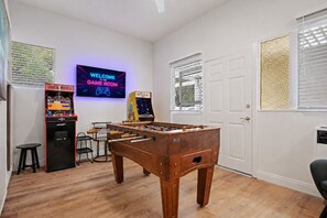 A room with a foosball table, two arcade machines, and a neon sign that reads 'WELCOME TO THE GAME ROOM.' - Casa La Vuelta - 4 King Suites Near Miramar Beach (Montecito)