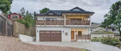 A two-story house with a garage, a balcony, and a driveway.