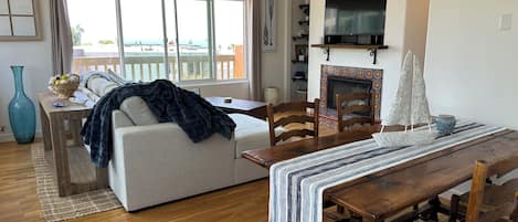 En hyggelig stue med en sofa, et spisebord og en pejs.