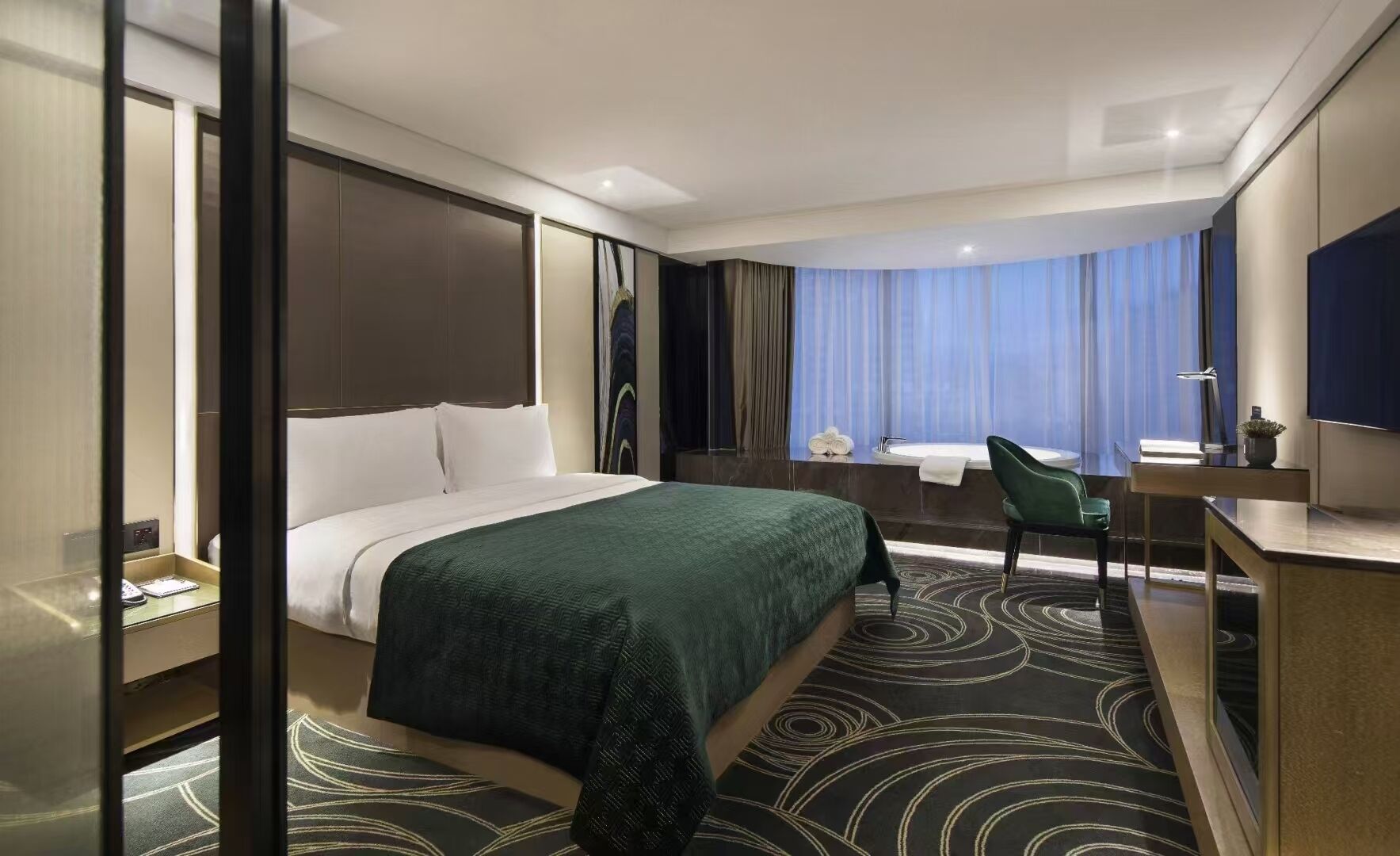 Habitación de hotel con cama, escritorio, silla, baño con bañera y una ventana grande con cortinas.