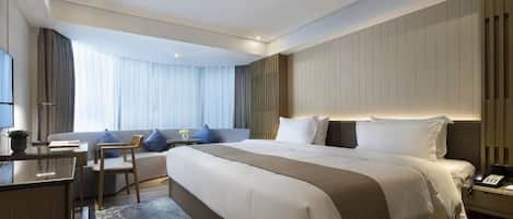 A modern hotel room with a large bed, a desk, and a chair.
