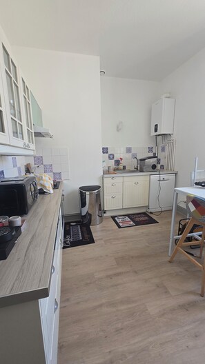 A compact kitchen with a microwave, toaster, and a coffee machine.