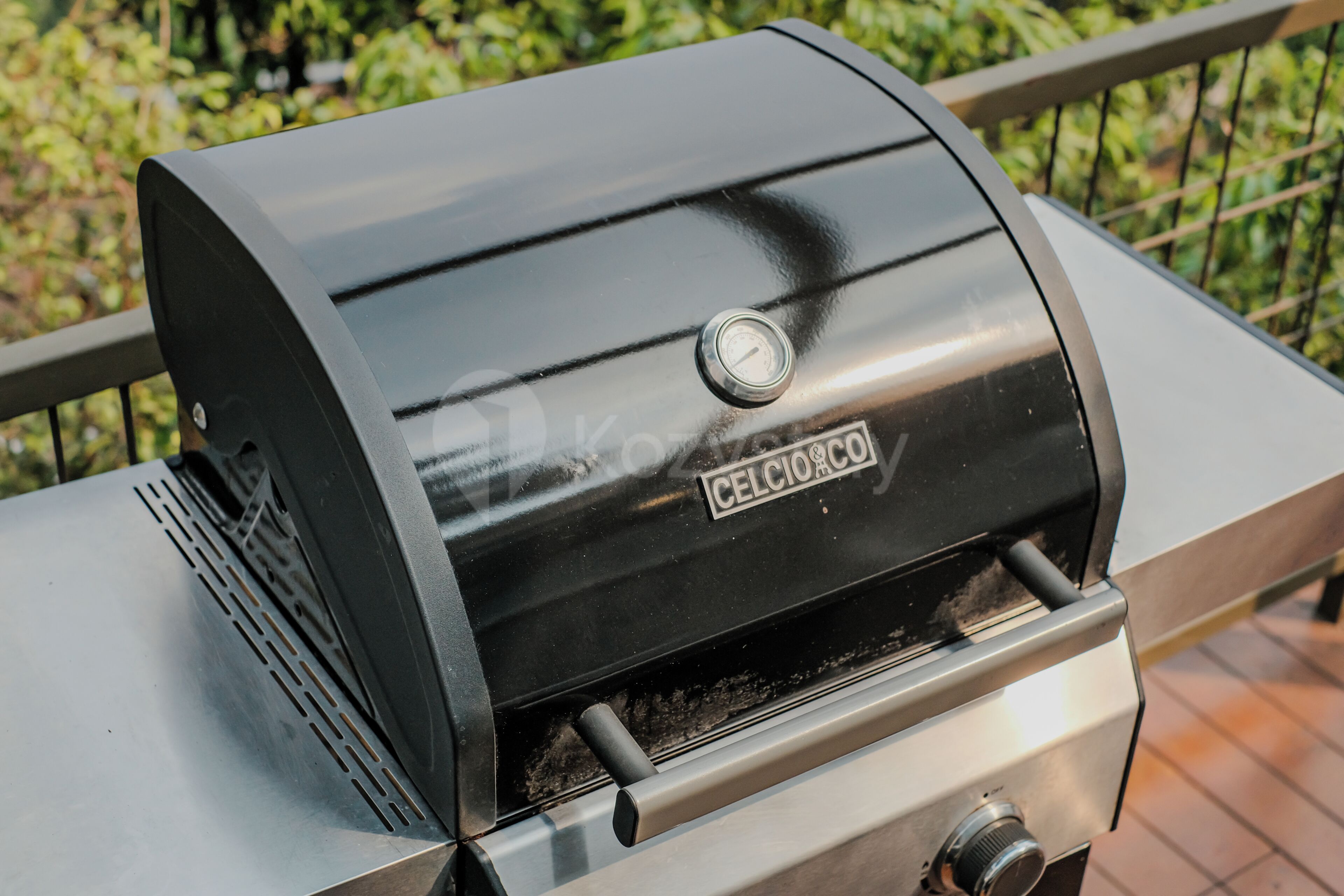 Una parrilla exterior negra con un dial y el nombre de la marca 'CELCIO'.