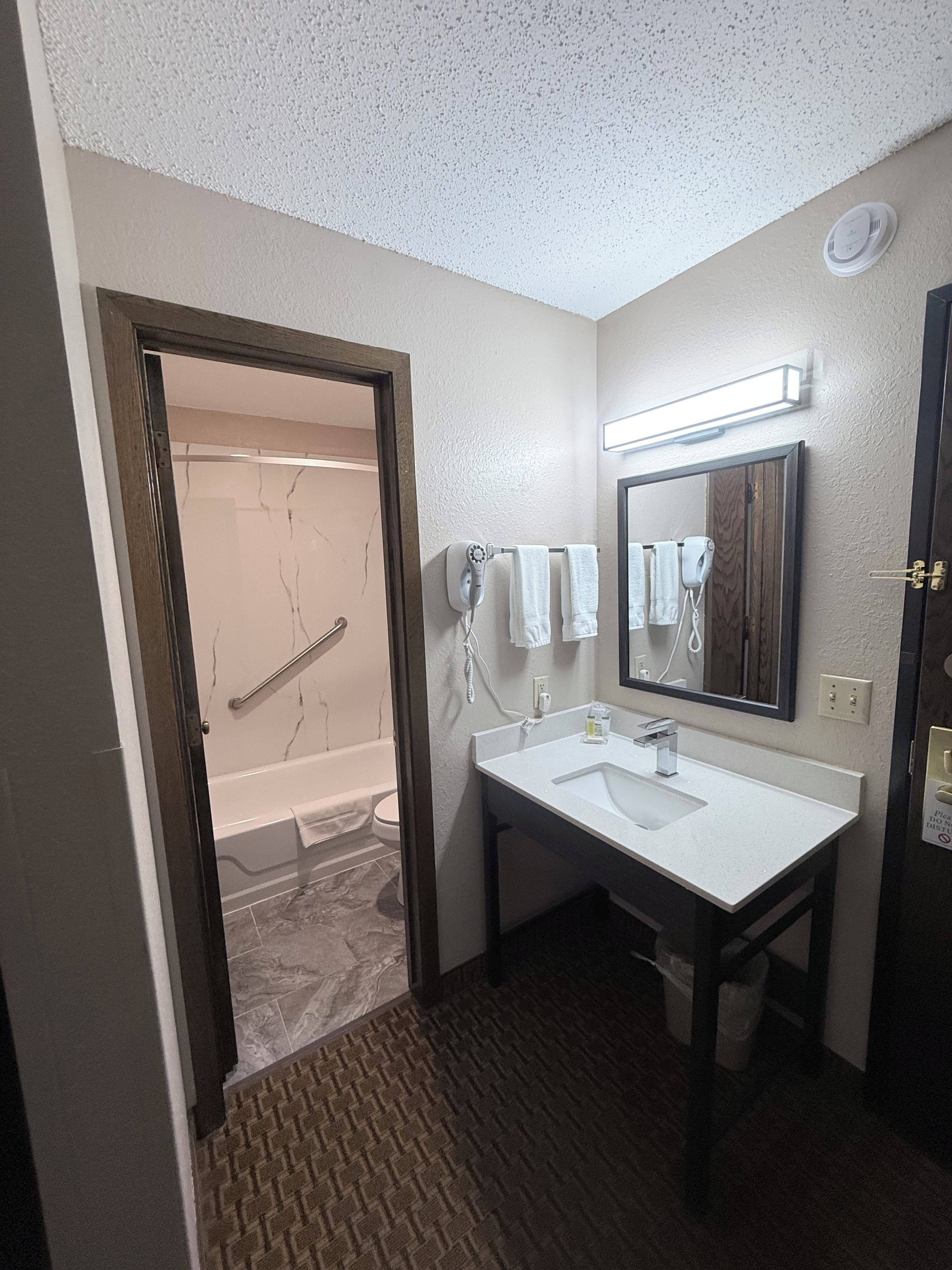 A bathroom with a bathtub, a sink, and a mirror.