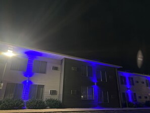 A multi-story building with exterior lighting. - Villa inn (Owatonna)