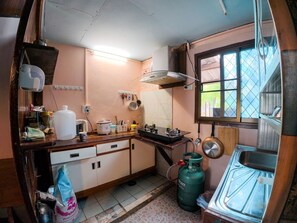 A compact kitchen with a gas stove, a sink, and a window providing natural light.