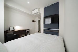 A hotel room with a bed, a desk with a chair, a flat-screen TV mounted on the wall, and an air conditioning unit. - R B Hotel Sendai East (Sendai)