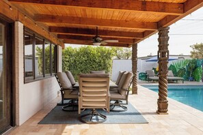 An outdoor patio with a pool, wooden ceiling, and two cushioned chairs. - Palmera Haus: Scottsdale Home, Pool & King Suites (Scottsdale)
