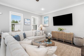 A living room with a sofa, a TV, and a window with blinds. - The Southern Riviera @ Inlet Beach, a boutique rental experience! (Inlet Beach)
