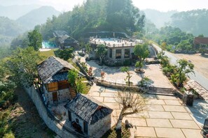 Uma vila tradicional com edifícios de pedra, um pátio pavimentado e uma estrada.
