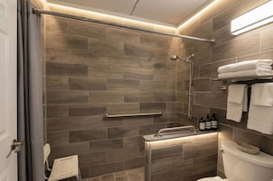 Un baño moderno con ducha, inodoro y toallero.