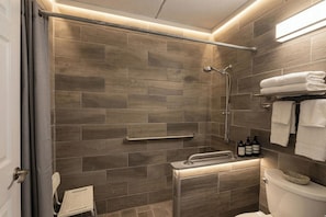 A modern bathroom with a shower, toilet, and a towel rack. - 8 Inn (Americus)