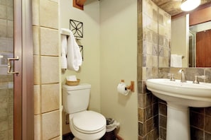 A bathroom with a toilet, a sink, and a mirror. - Bear Tracks #2020 (Big Bear Lake)