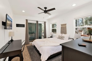 Ein modernes Schlafzimmer mit Bett, Schreibtisch und Deckenventilator.