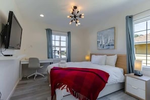A hotel room with a bed, desk, chair, and a television. - Marbella Lane Convenient Home In Sunnyvale (Sunnyvale)
