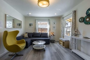 A modern living room with a sofa, a yellow chair, a coffee table, and a window with curtains. - Marbella Lane Convenient Home In Sunnyvale (Sunnyvale)