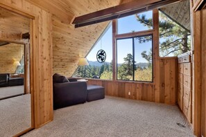 Una habitación acogedora con un ventanal grande, un sofá y una lámpara.