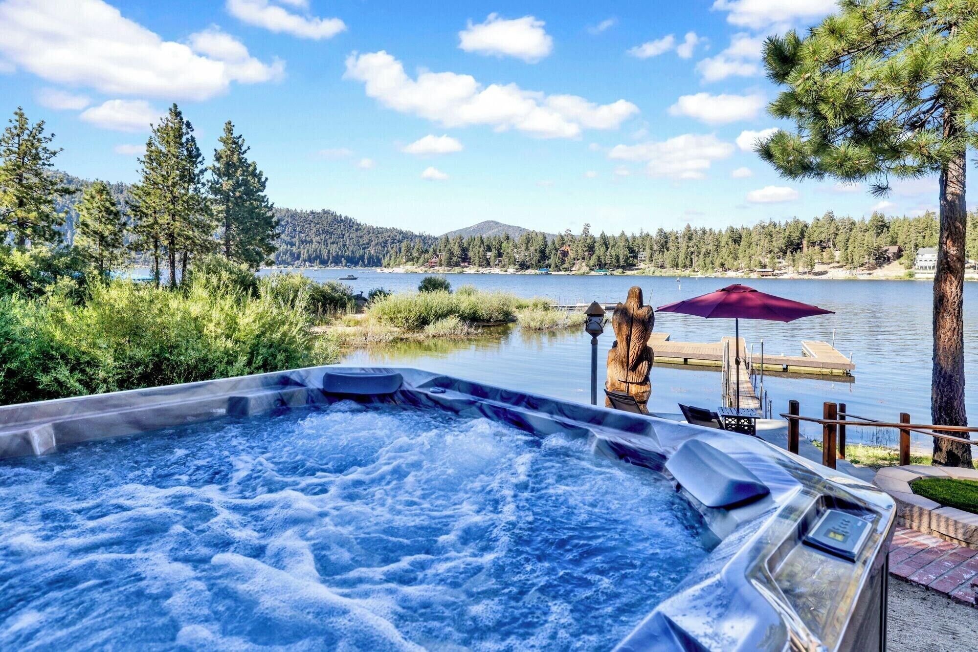 Un jacuzzi con vista a un lago y un bosque.