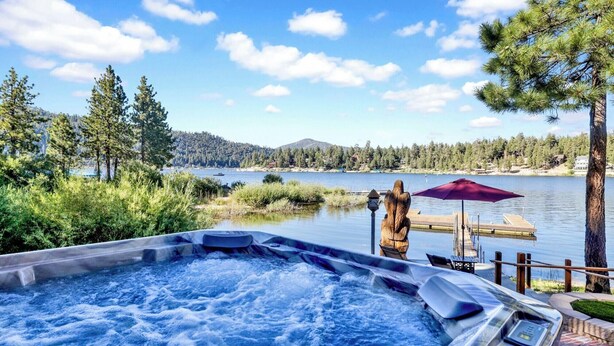 A hot tub with a view of a lake and forest. - Cove Lakefront Chalet #2098 (Big Bear Lake)