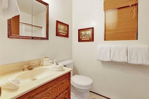 A bathroom with a sink, mirror, toilet, and towel rack. - Bearadise Cottage #2275 (Big Bear Lake)